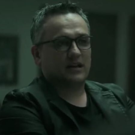 Joe Russo is wearing glasses, black suit and a black t-shirt.